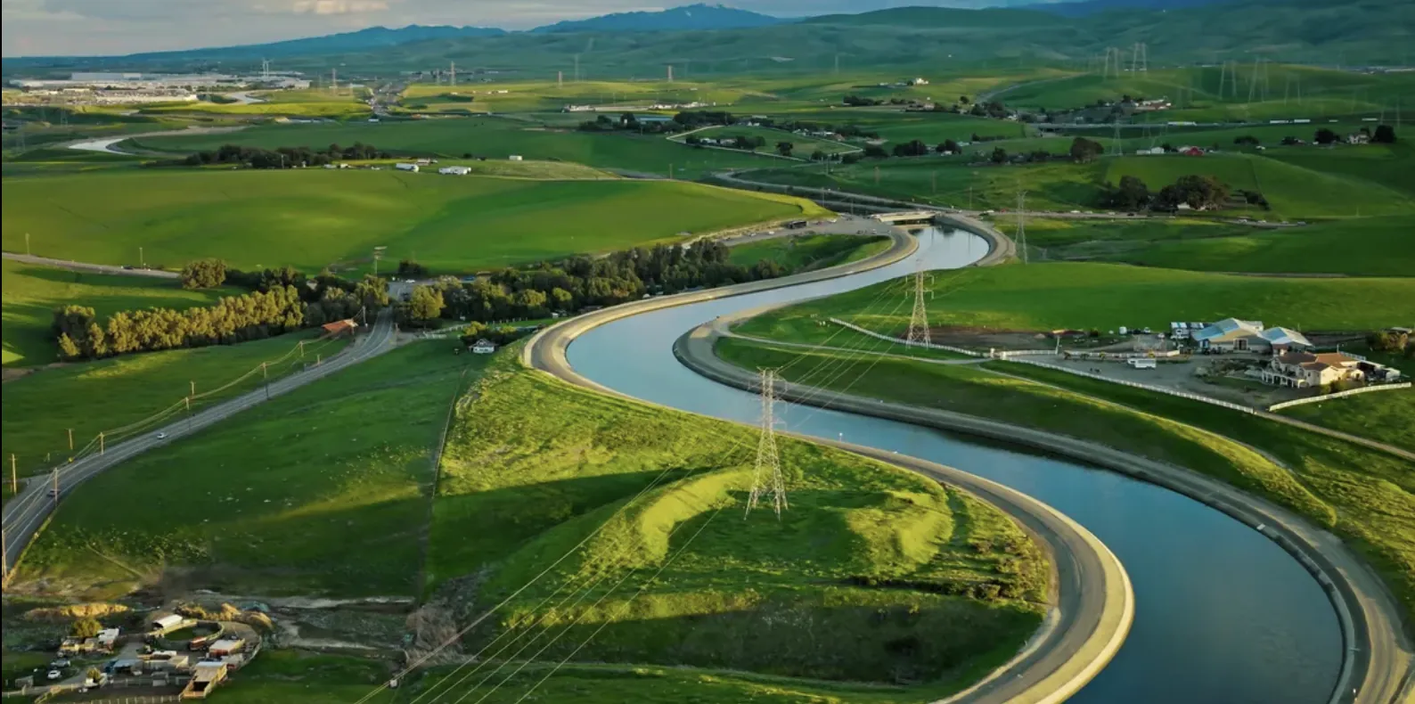 Aerial view of green farmland and a winding waterway